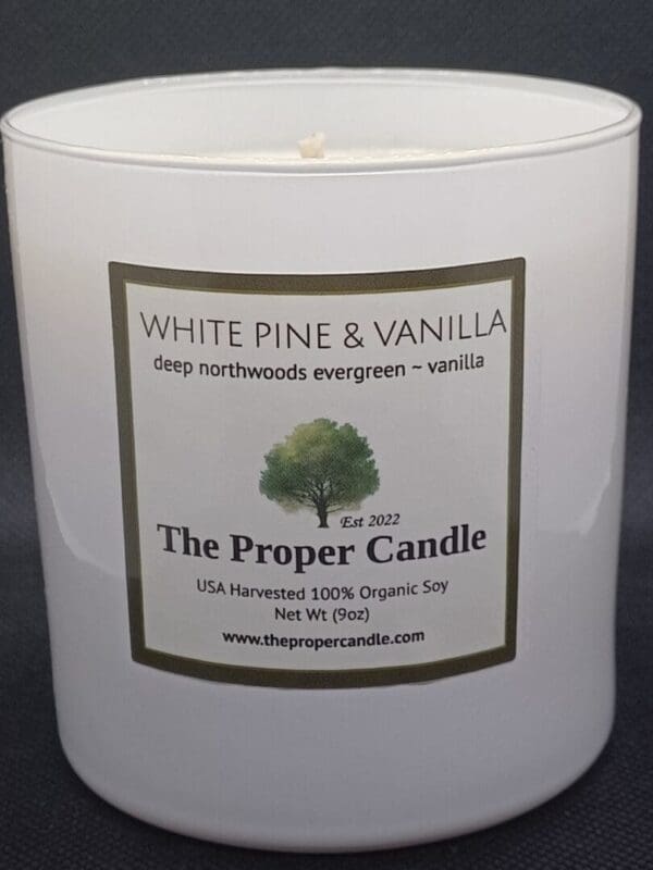 A white candle with the label of a tree.