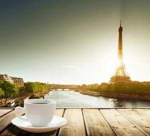 A cup of coffee sitting on top of a wooden table.