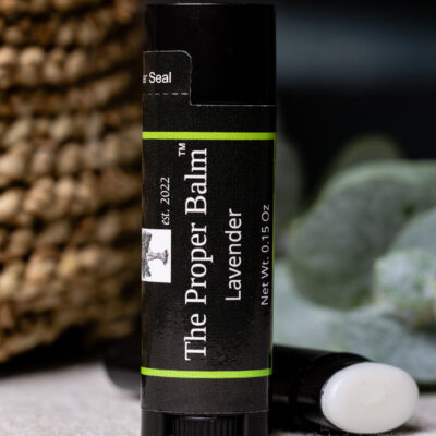 Lavender lip balm tube on a surface.