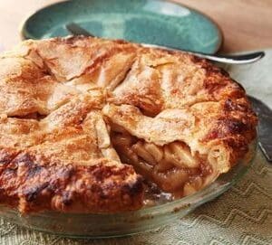 A pie with apples sitting on top of the table.