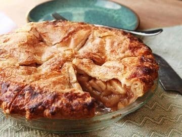 A pie with apples sitting on top of the table.