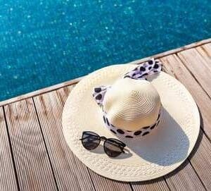 A hat and sunglasses on top of a white plate.