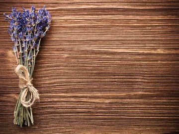 A wooden table with lavender tied to it.