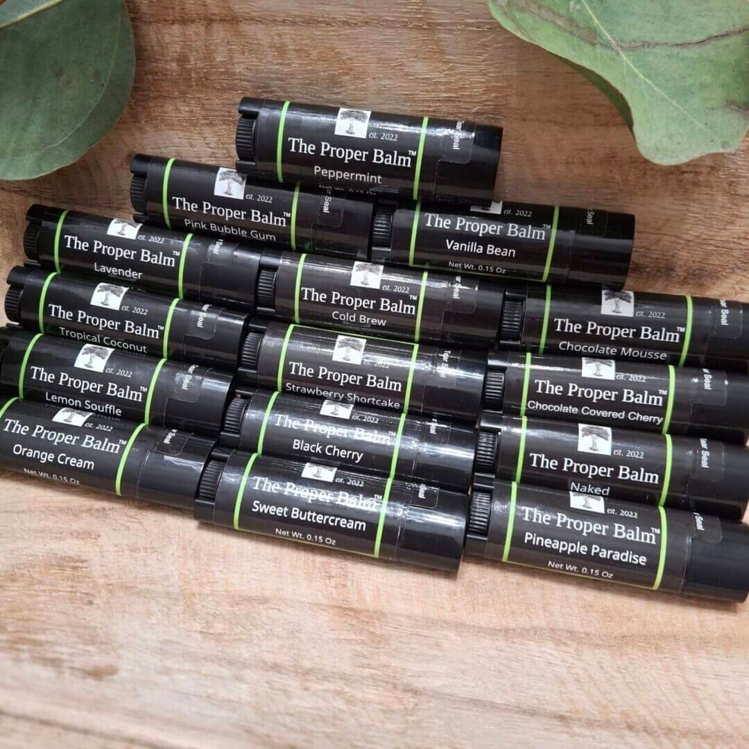 Various flavored lip balms on wooden surface.