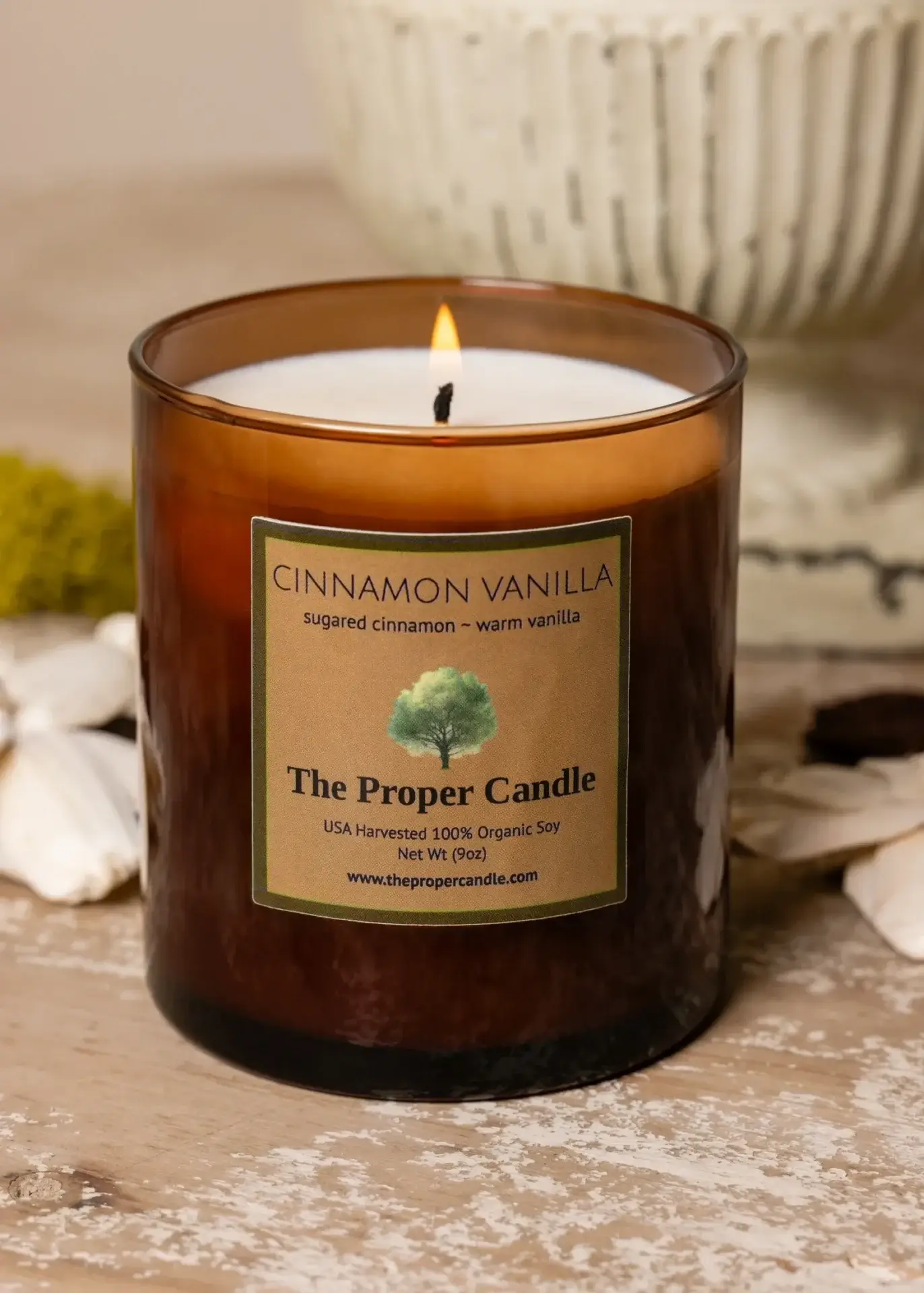 Cinnamon vanilla scented candle on wooden table.