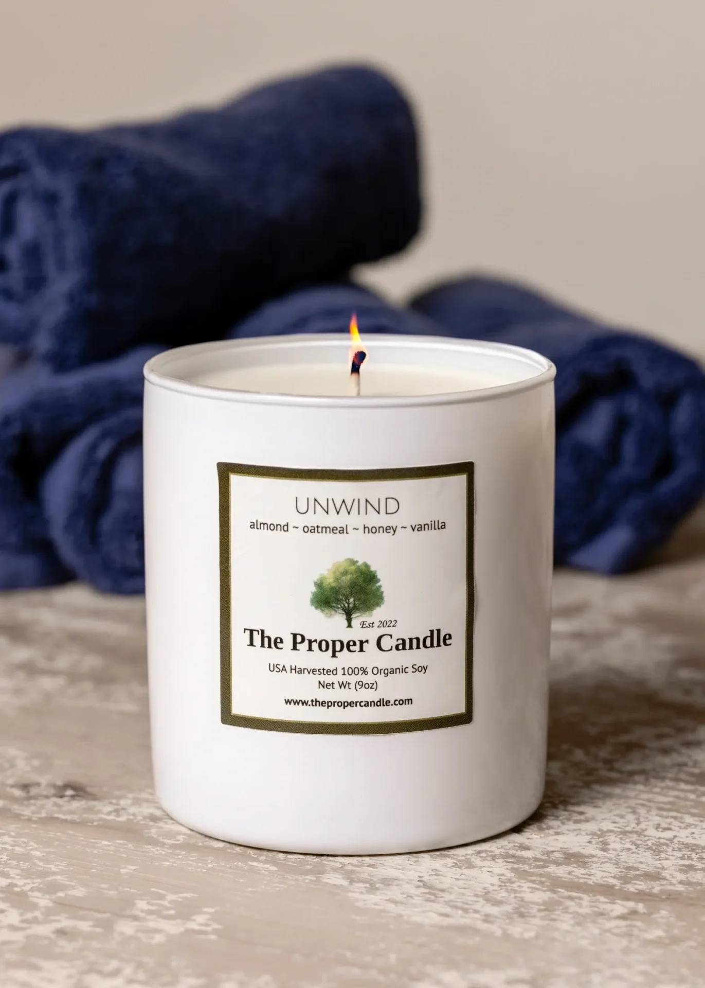 Candle labeled "Unwind" with blue towels.